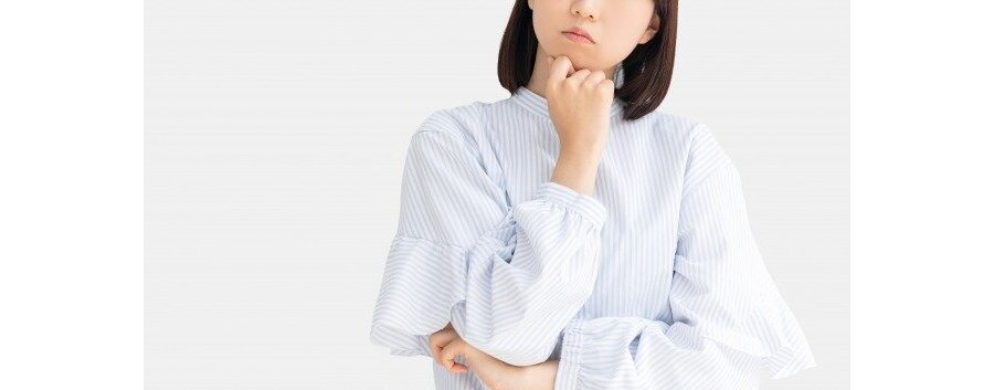 考え事をしている白い服の女性