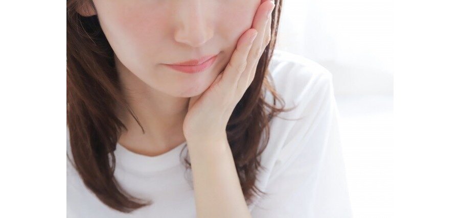 頬に手を当てて歯を痛がる女性