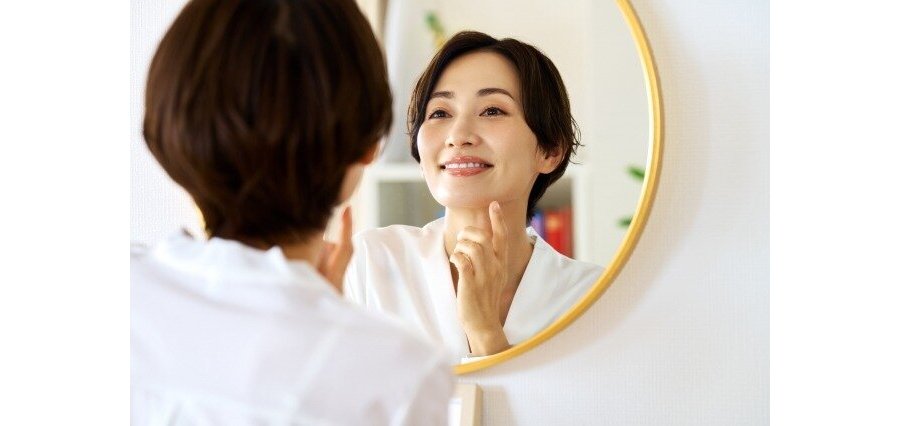鏡で顔を見ている女性