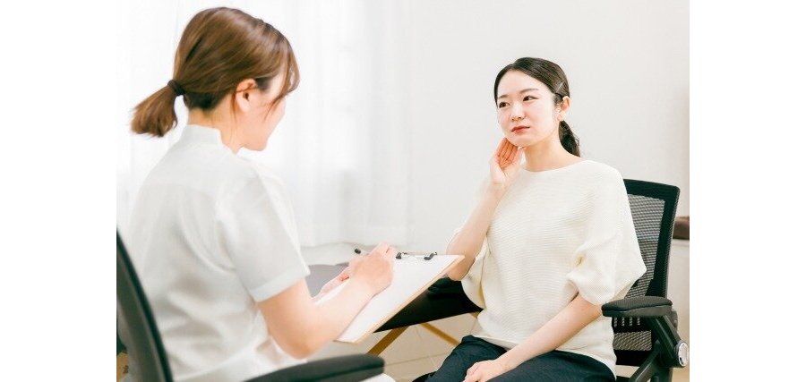 顎を痛がりカウンセリングを受ける女性